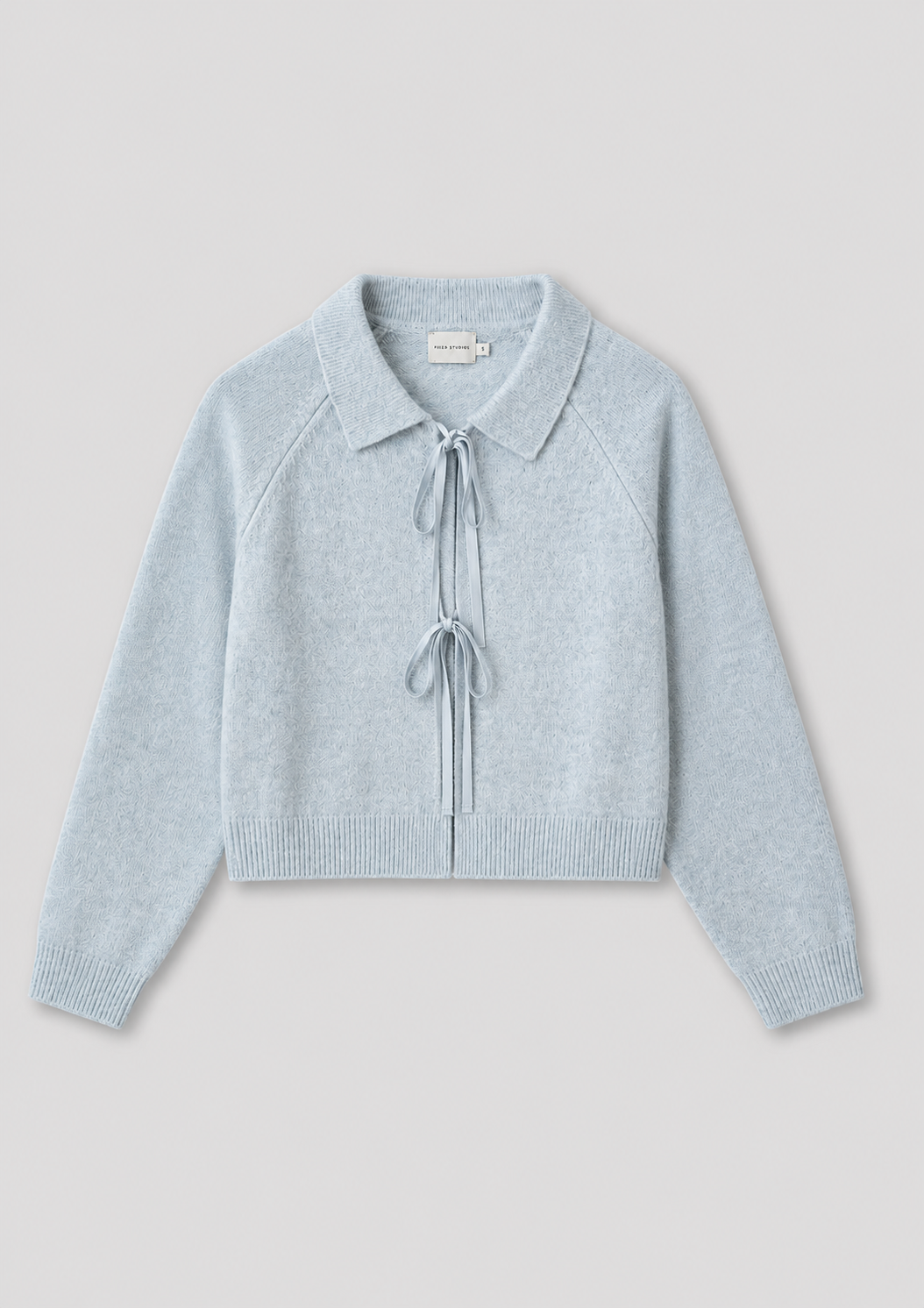 The Box Cardigan - Young Blue is a light blue, long-sleeve knit cardigan featuring a collar and two front tie closures at the chest and waist, inspired by Deiji Studios, shown on a plain light gray background.