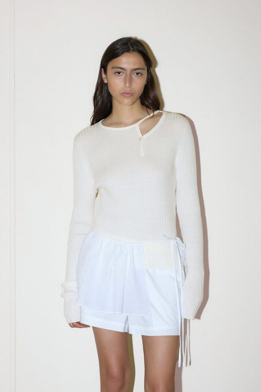 dark haired female model wears a white fully fashioned ribbed knit features flattering high neckline, cut out collar with single button feature, paired with a white easy pull-on boxer short designed to fit mid-rise, features a gathered elastic waistline with double button detailing