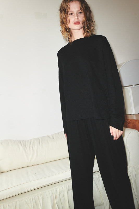 Female model wearing soft pant - black by Deiji Studios against plain background