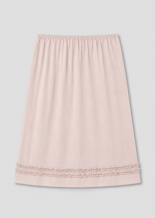 The Daytime Skirt - Floss is a light pink, knee-length cotton voile skirt with an elastic waistband and two rows of lace trim near the hem, shown on a plain white background—ideal for daytime wear.