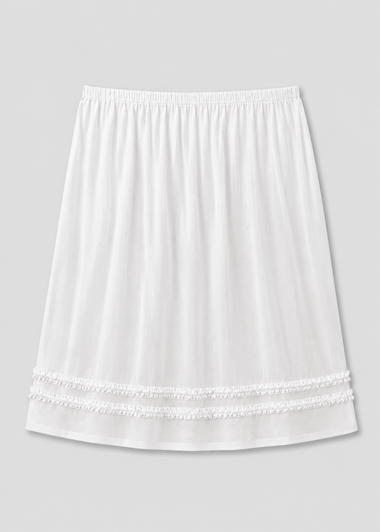 The Daytime Skirt - White is a plain cotton voile midi skirt with an elastic waistband and two rows of decorative lace near the hem, shown on a light gray background.