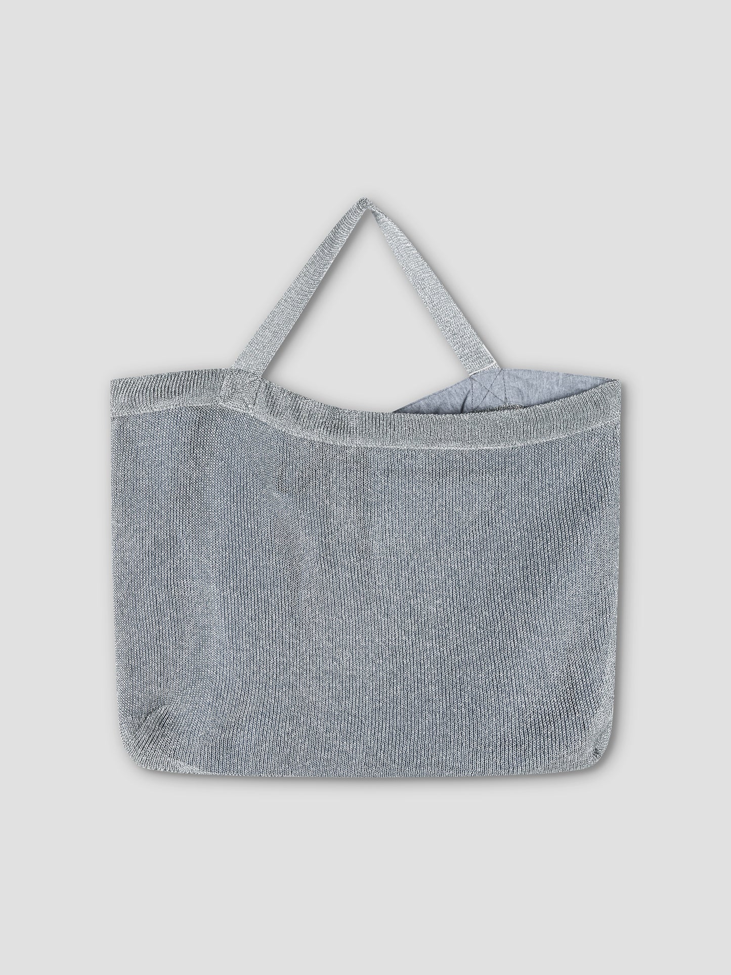 The Chain Bag - Silver, a metallic mesh shoulder bag with two handles, is showcased against a plain light gray background.