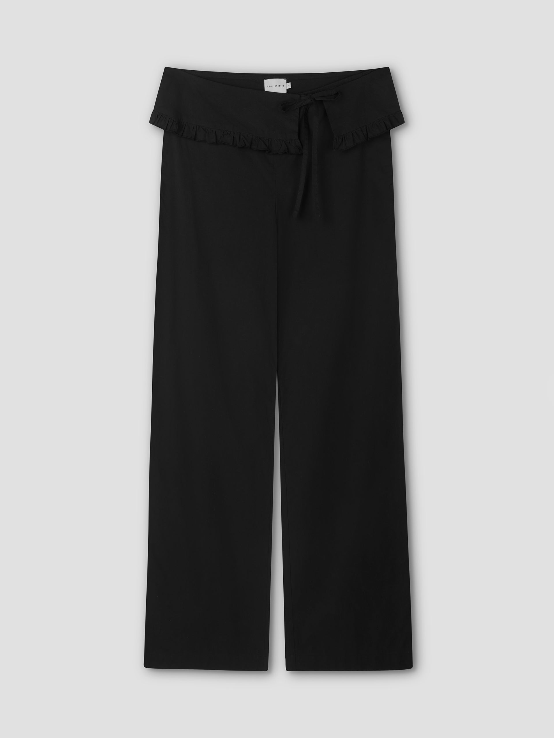 The Flounce Belt Pant - Black features a ruffled waistband, front tie bow, and straight-leg design. Displayed flat against a light gray background, it offers a relaxed fit and effortlessly chic style.