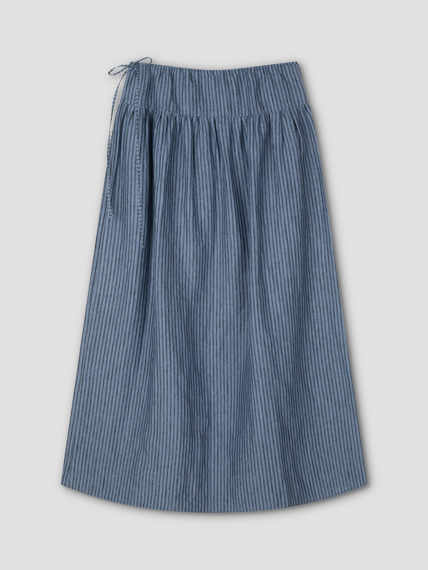 The Maxi Skirt - Azure Stripe is a blue and gray, knee-length skirt with a gathered waistband and drawstring tie on the left, shown flat against a light background.