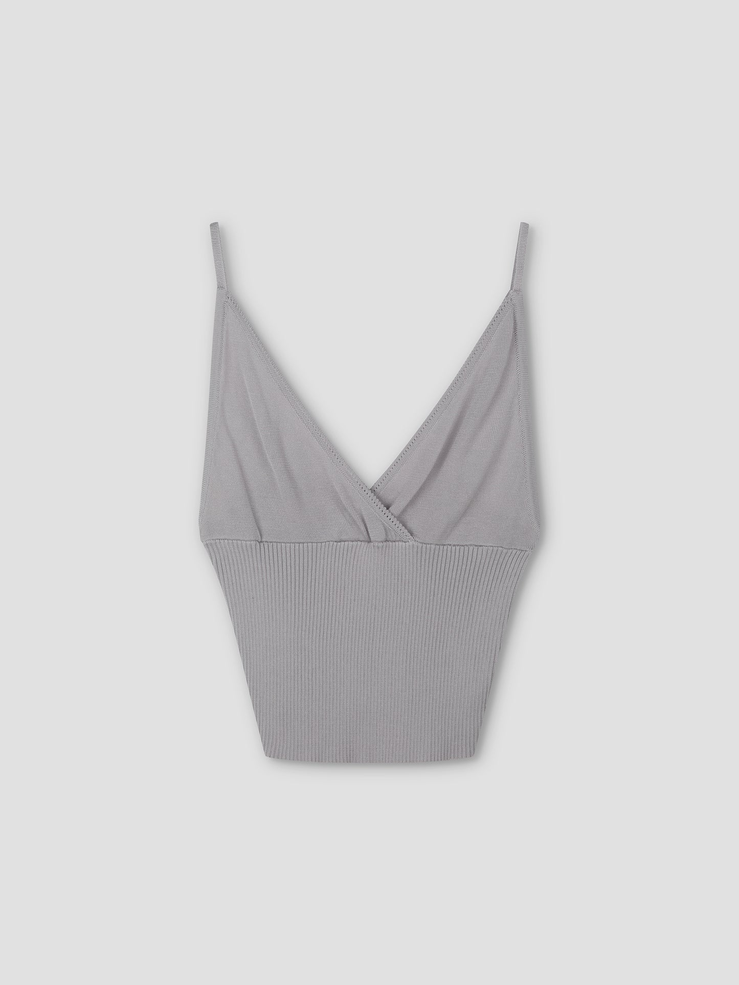 The Cross Panel Knit Top in soft lilac is a cropped tank with thin spaghetti straps, a V-neckline, and ribbed texture on the lower half, inspired by Deiji Studios.