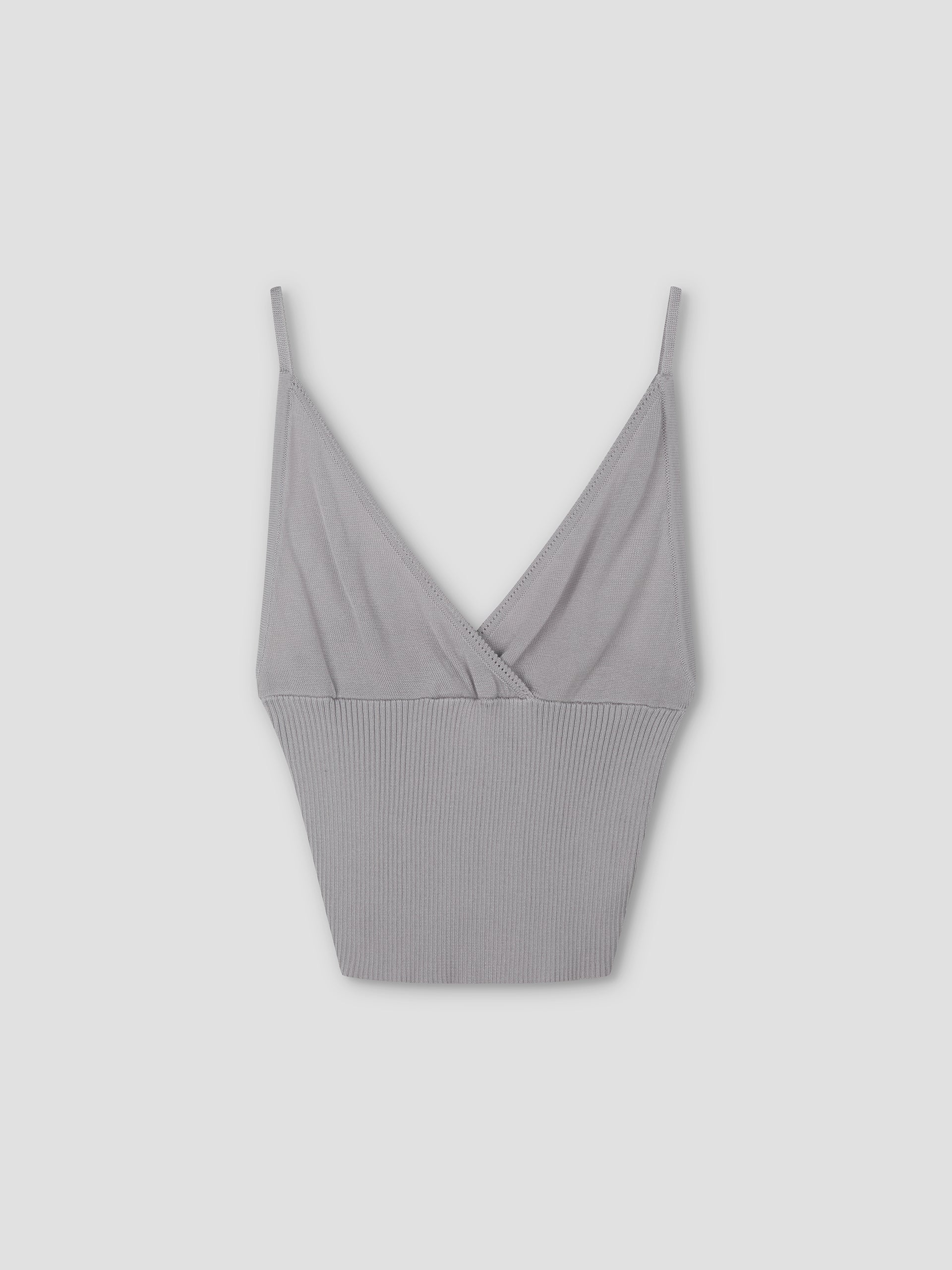 The Cross Panel Knit Top in soft lilac is a cropped tank with thin spaghetti straps, a V-neckline, and ribbed texture on the lower half, inspired by Deiji Studios.