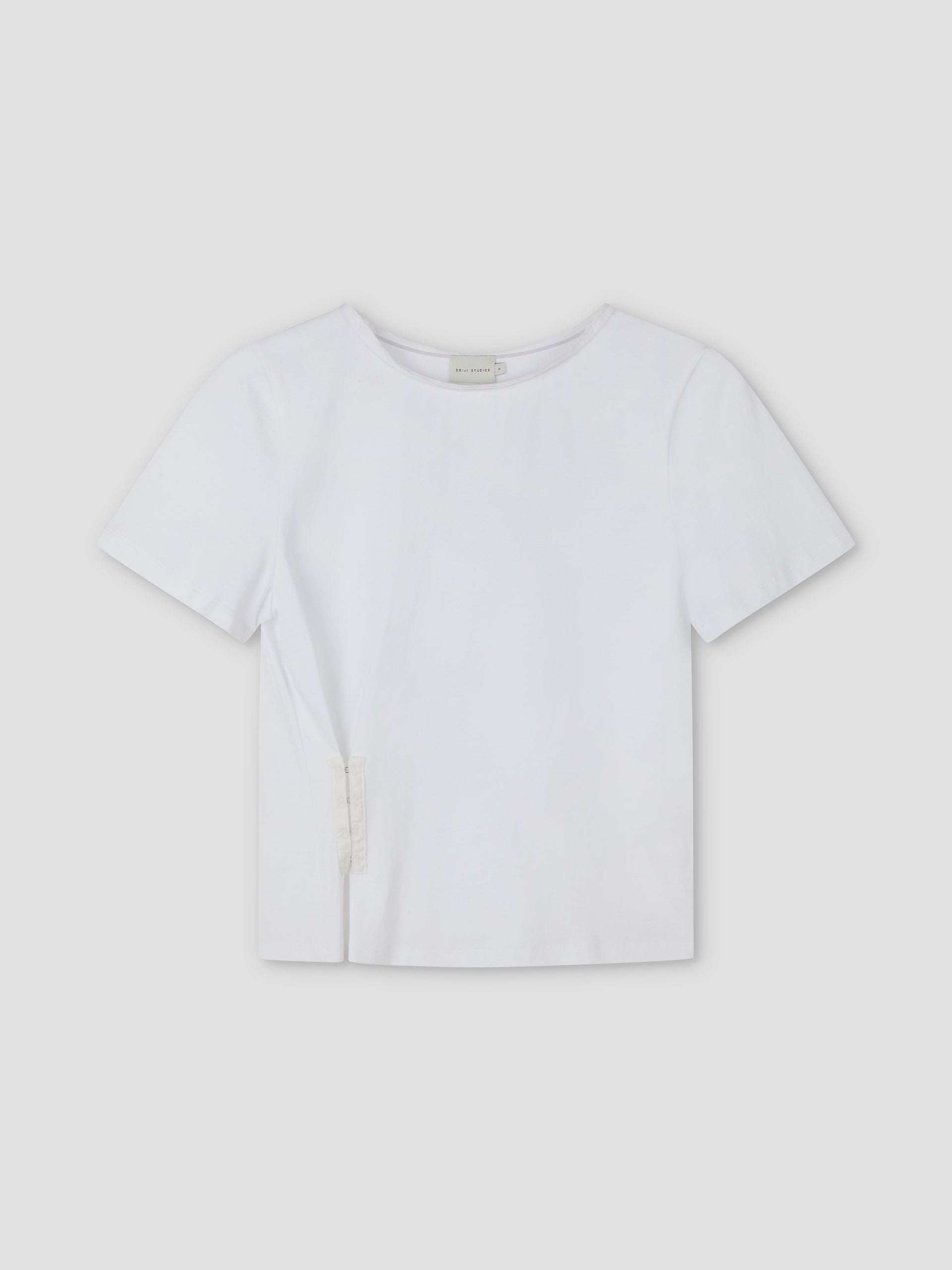 The Pinch Tee - White is a relaxed short sleeve tee featuring a classic crew neckline and a distinctive pinched side seam detail near the hem, shown on a light gray background.