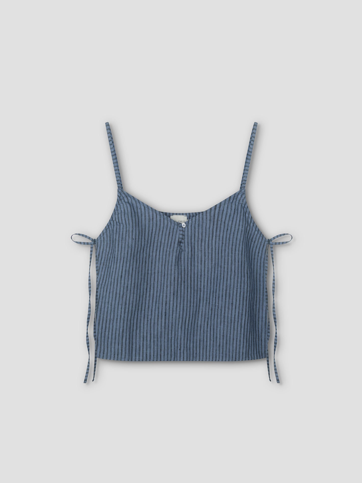 The V Neck Cami - Azure Stripe by Deiji Studios features blue and black vertical stripes, thin shoulder straps, side ties, and a front button detail, shown on a plain light background.