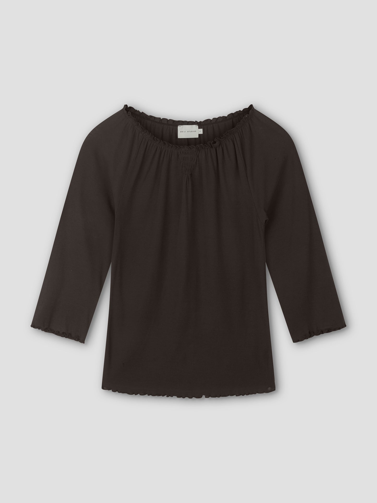 A brown, cotton flounce 3/4 sleeve top with an elastic neckline and ruffled edges on the sleeves and hem, laid flat on a light gray background.