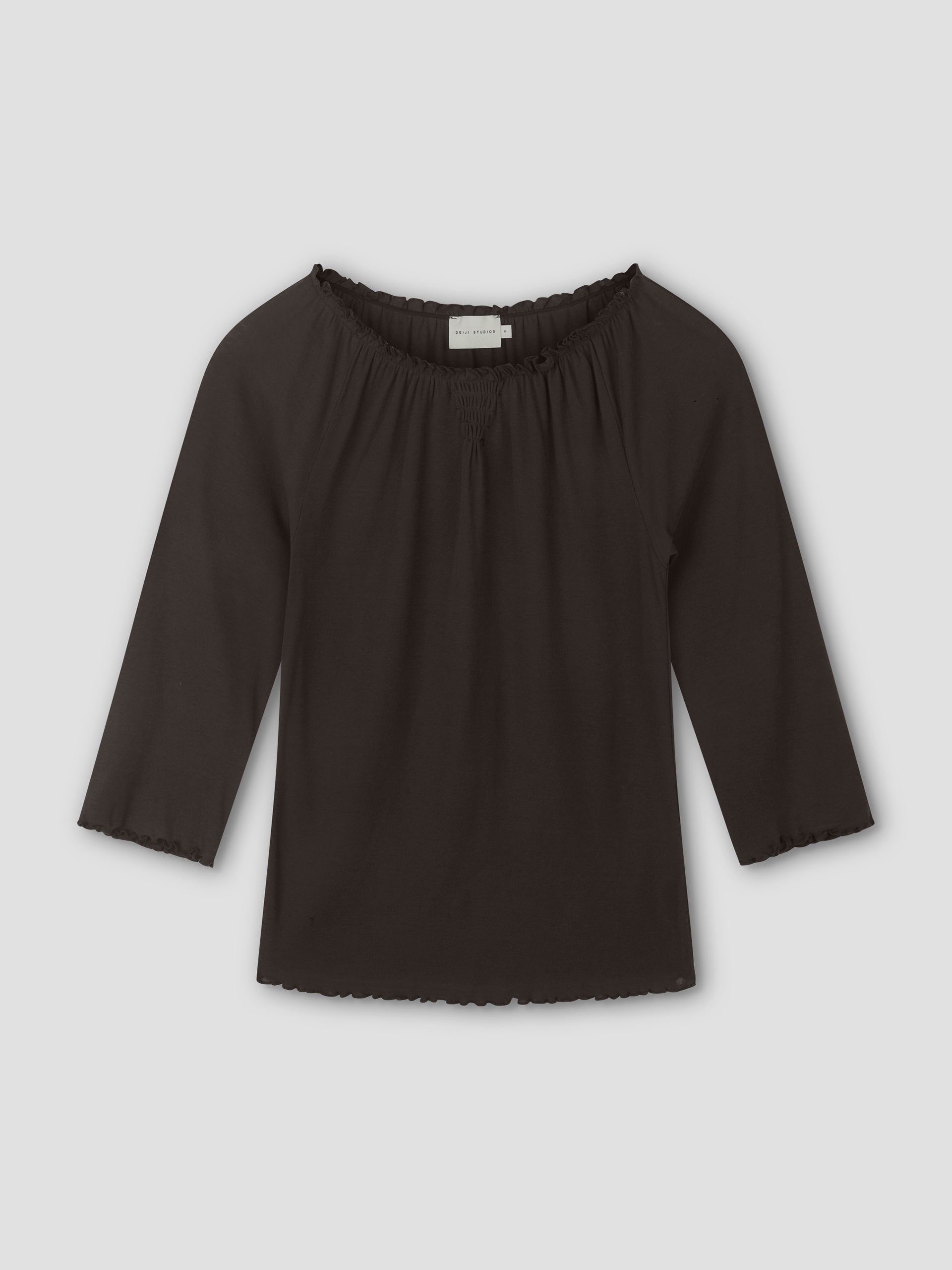 A brown, cotton flounce 3/4 sleeve top with an elastic neckline and ruffled edges on the sleeves and hem, laid flat on a light gray background.