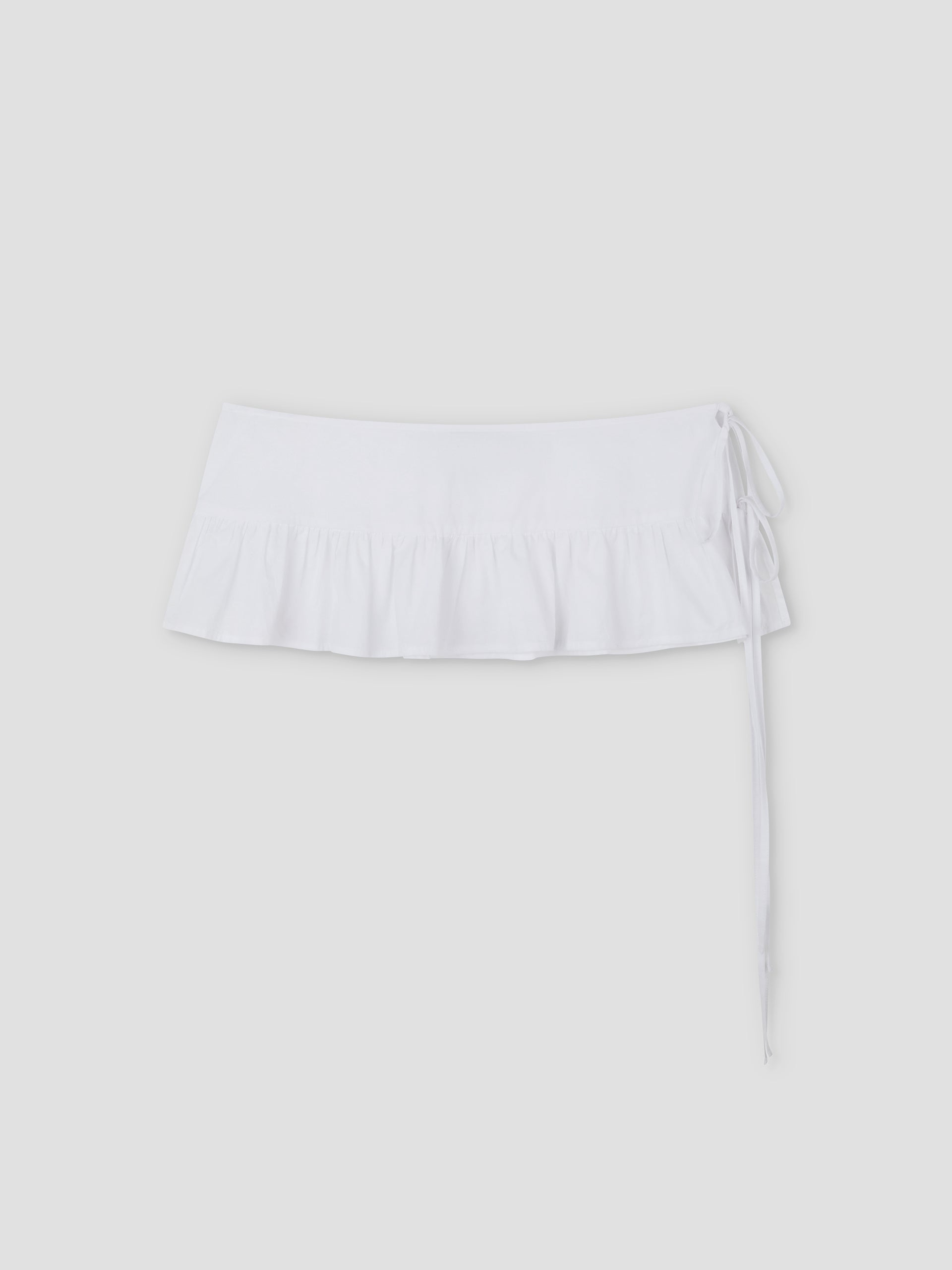 Flounce Belt - White mini skirt featuring a ruffled hem and stylish flounce belt detail on the right, shown against a plain light grey background.