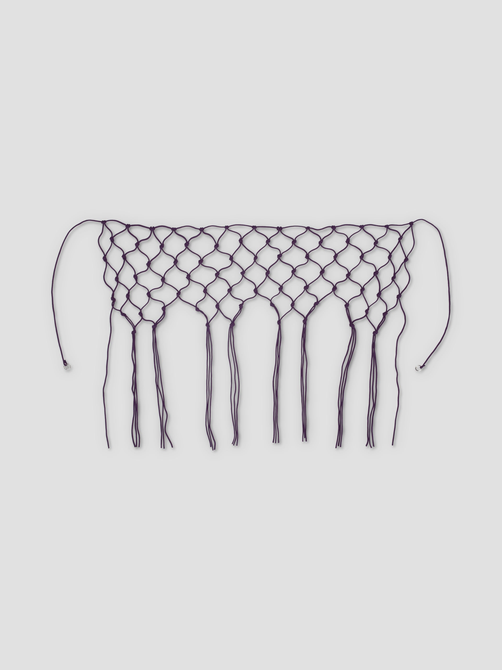 The Macrame Belt - Burgundy features a netted, diamond pattern with long fringe and two strings at each end, crafted from recycled polyester and shown on a white background.