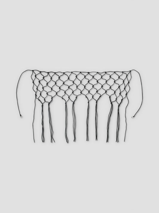 The Macrame Belt - Black is a handwoven belt made from recycled polyester, featuring large diamond-shaped netting and long fringe strands, shown against a plain white background.
