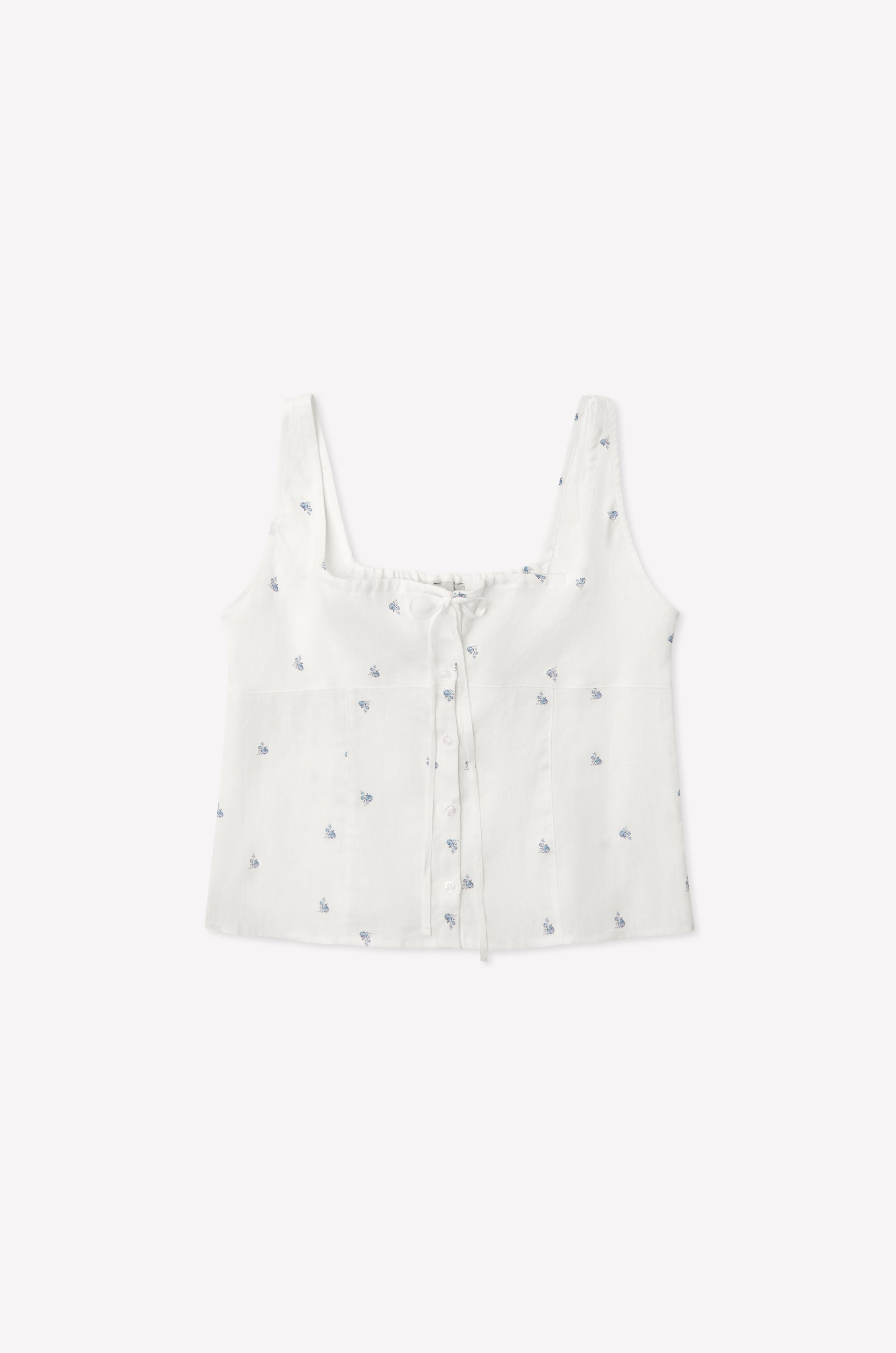 The Relax Tie Top - Floral Blue is a white linen crop tank with a square neckline, button front, blue embroidered floral pattern, and front tie detail in lightweight, textured fabric inspired by Deiji Studios.