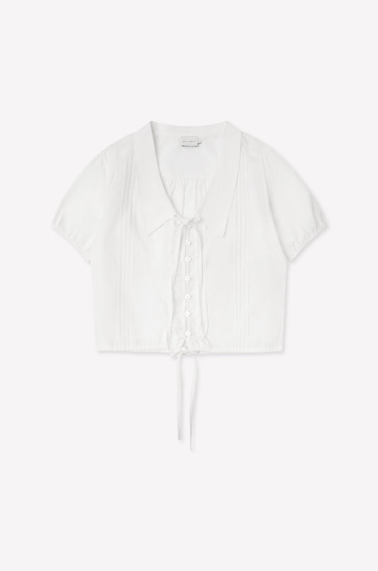 The Fine Collar Top - White features a collared v-neck, short sleeves, button-down front, pintuck details, and a waist tie—crafted from cotton poplin with signature Deiji Studios elegance.