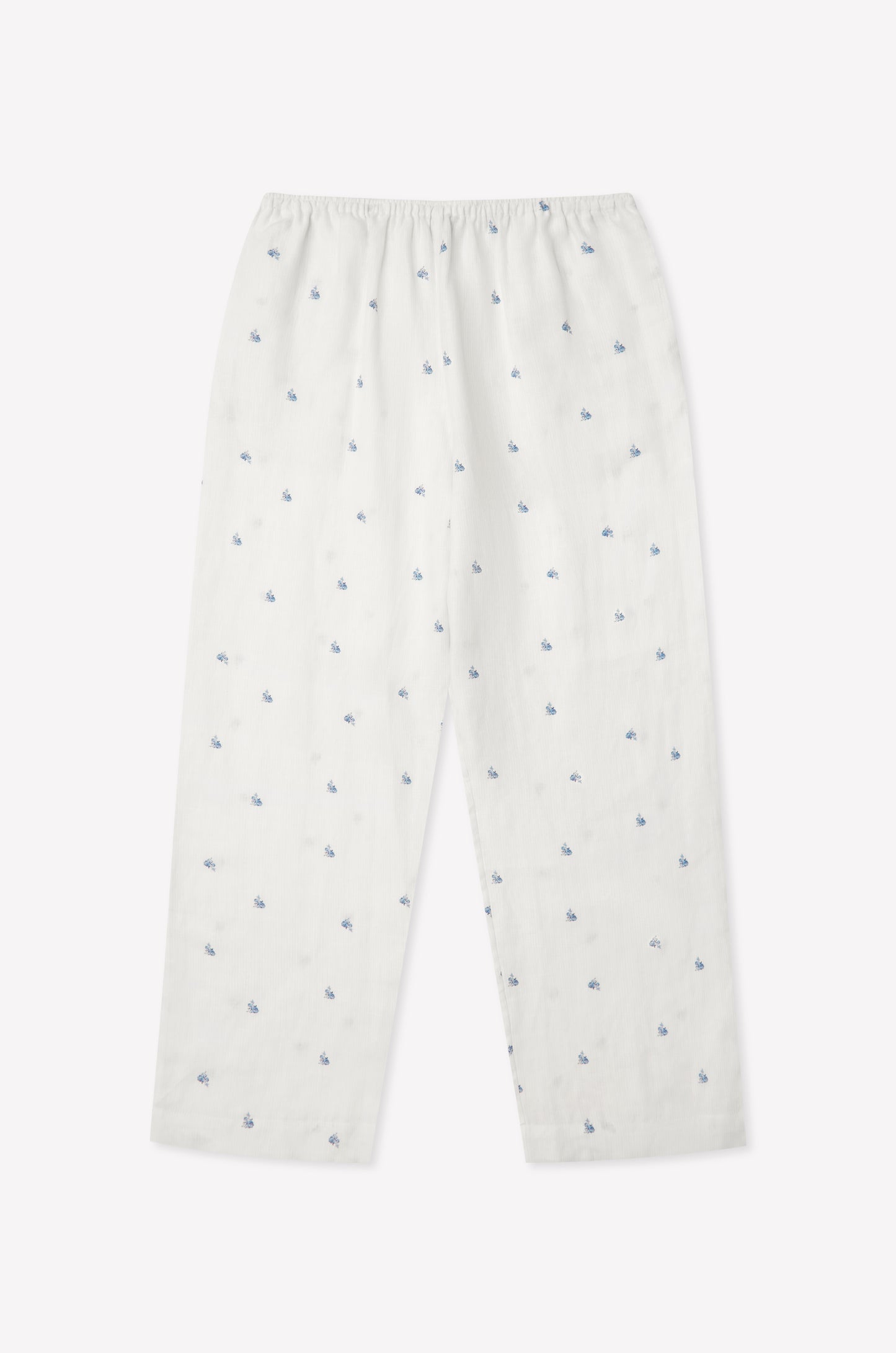 The Linen Ease Trouser - Floral Blue features a relaxed fit, elastic waist, and an evenly distributed blue floral print on white linen, shown against a plain light background.
