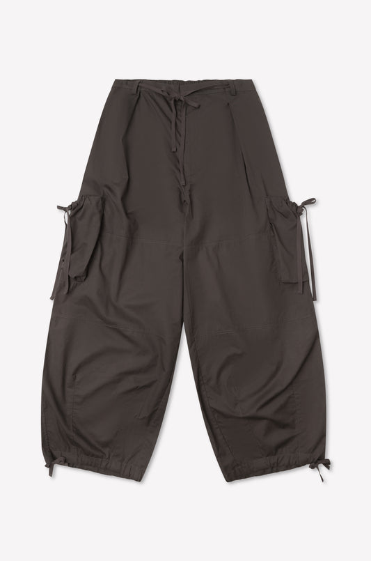 The Cargo Pant - Carob by Deiji Studios is a loose-fitting dark brown cargo pant with large side pockets, adjustable waist and ankle drawstrings, and wide-leg silhouette, shown flat on a plain white background.