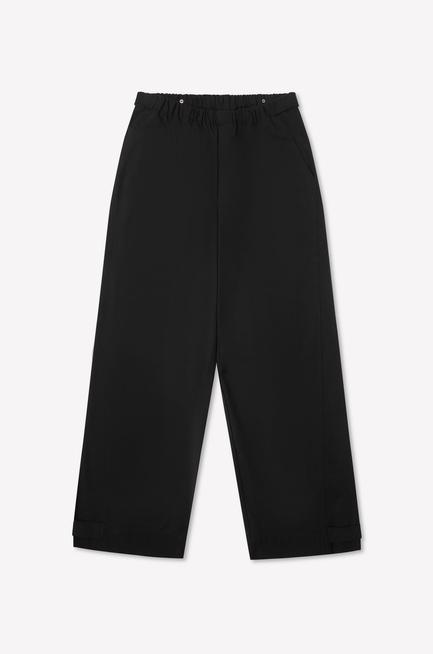 Snap Tab Pant - Black by Deiji Studios features a wide-leg silhouette, elastic waistband, side pockets, and adjustable hem straps. Shown laid flat on a white background.