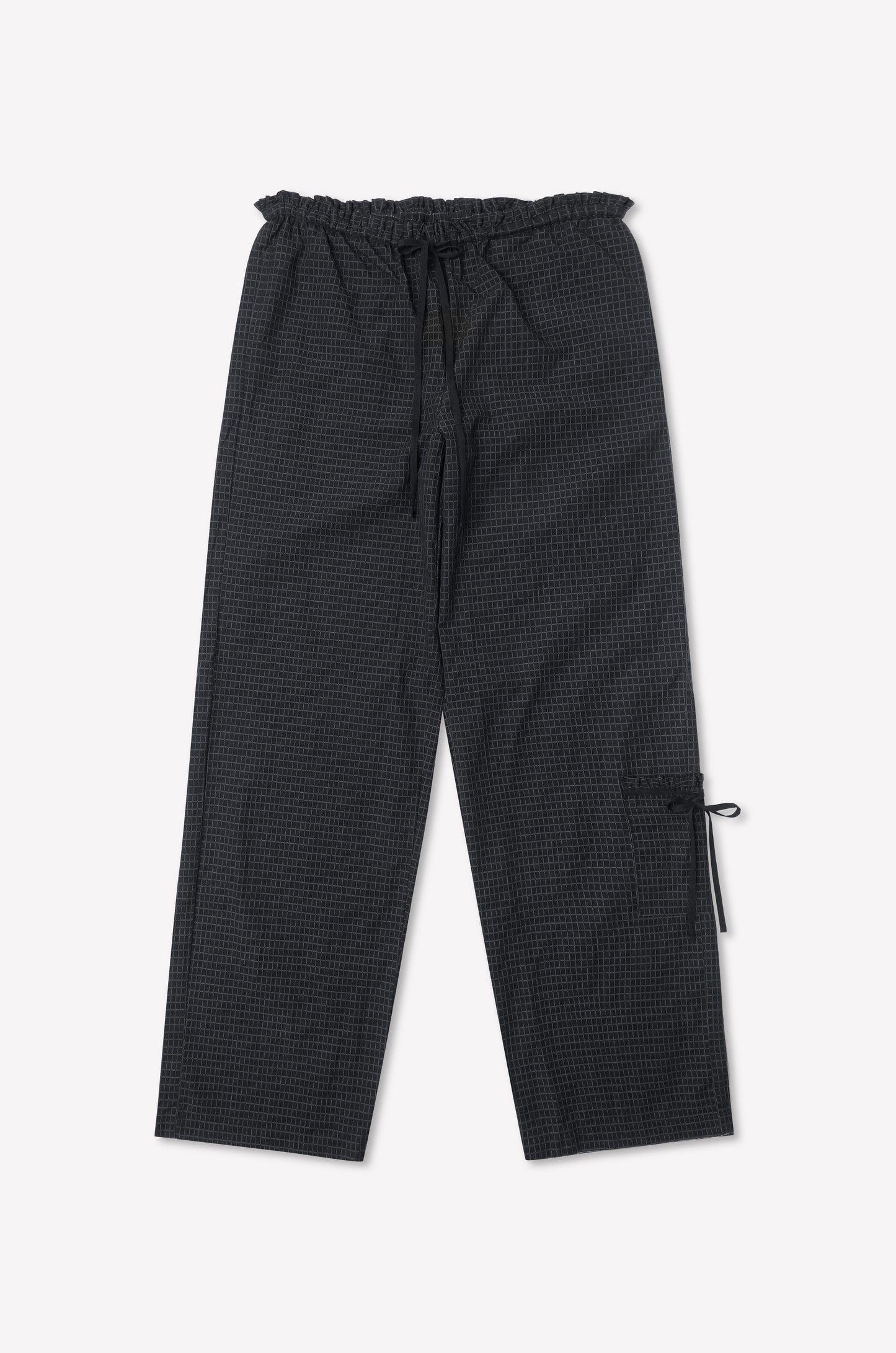 The Grosgrain Pant - Mono Grid is a loose-fit black checkered pant with relaxed legs, a drawstring waist, side pocket with tie detail, inspired by Deiji Studios, shown on a white background.