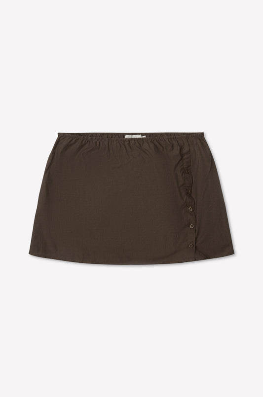 The Pleat Split Skirt - Toast is a brown cotton poplin mini skirt with an elastic waistband and side button detailing, shown laid flat on a white background.