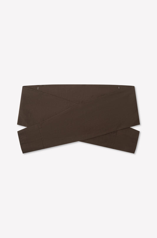 The Shirt Cuff Belt - Toast by Deiji Studios is a wide, dark brown cotton poplin belt with a crisscross design, shown flat on a white background.