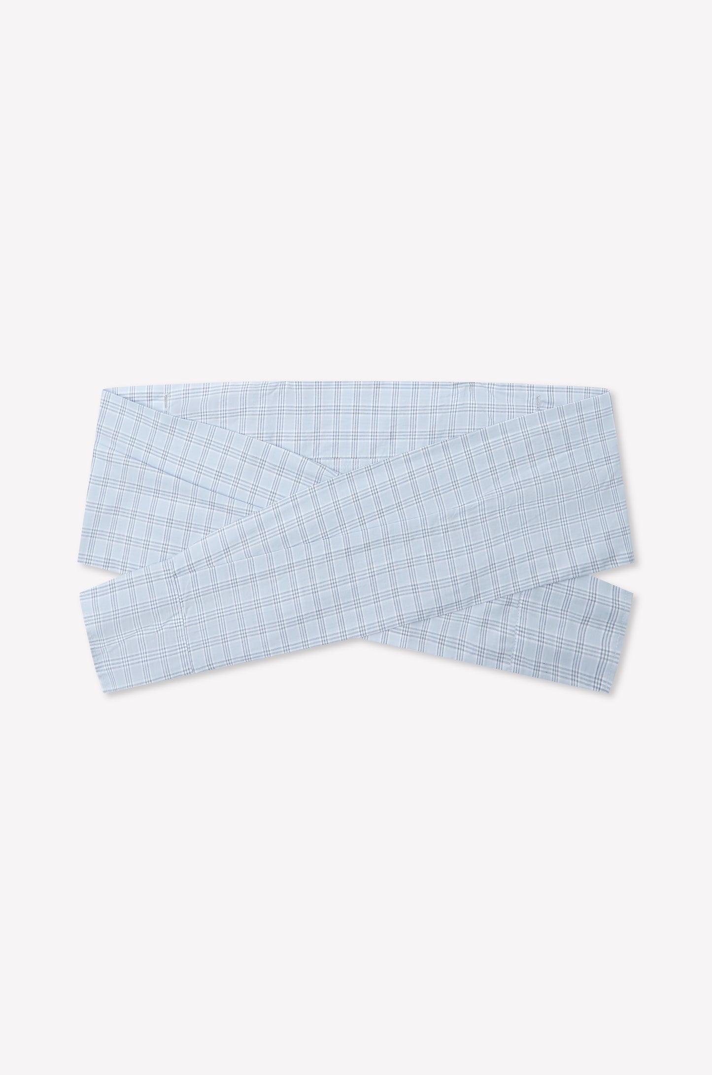 The Shirt Cuff Belt - Powder Check is a light blue plaid cotton poplin belt with a crisscross wrap design, inspired by Deiji Studios, shown on a plain white background.