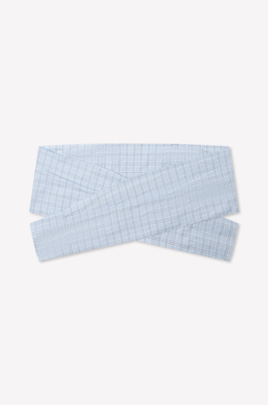 The Shirt Cuff Belt - Powder Check is a light blue plaid cotton poplin belt with a crisscross wrap design, inspired by Deiji Studios, shown on a plain white background.