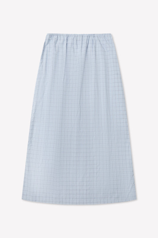 The Way Skirt - Powder Check is an ankle-length, light blue organic cotton skirt with a subtle check pattern and elastic waistband, shown flat on a white background, inspired by Deiji Studios' effortless style.