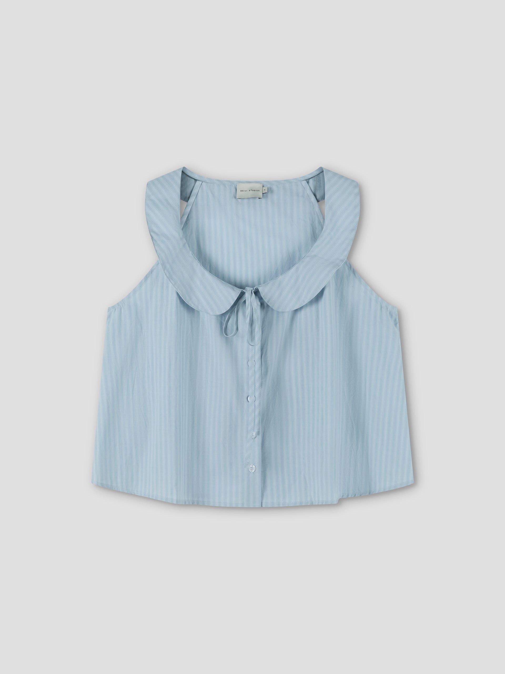 The Round Collar Top - Lake Blue Stripe features a sleeveless design, subtle vertical stripes, a wide round collar, and front tie detail, showcased against a plain light background. Inspired by the effortless elegance of Deiji Studios.