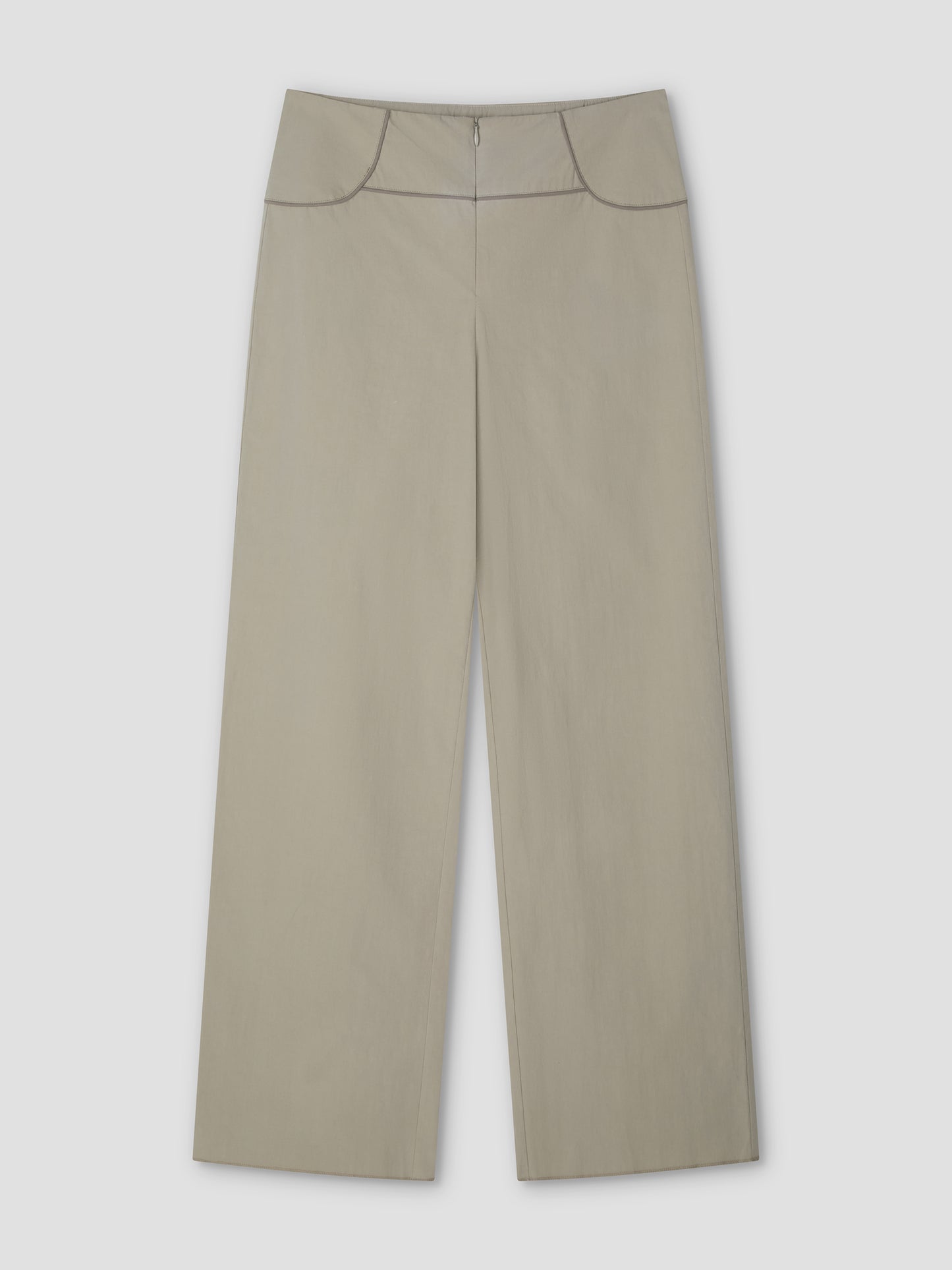 The Panelled Pant - Stone by Deiji Studios features a high waist, front zipper, and dark piping along the waistband and pockets. These wide-leg pants in light beige are shown laid flat on a plain, light background.