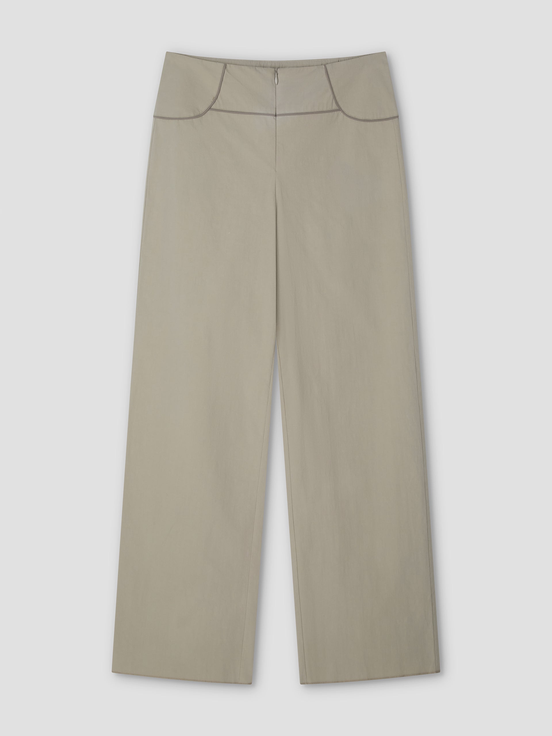 The Panelled Pant - Stone by Deiji Studios features a high waist, front zipper, and dark piping along the waistband and pockets. These wide-leg pants in light beige are shown laid flat on a plain, light background.