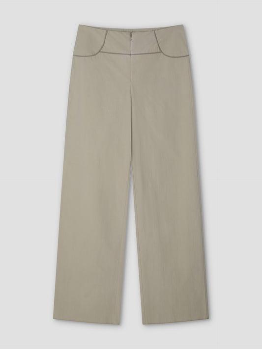 The Panelled Pant - Stone by Deiji Studios features a high waist, front zipper, and dark piping along the waistband and pockets. These wide-leg pants in light beige are shown laid flat on a plain, light background.