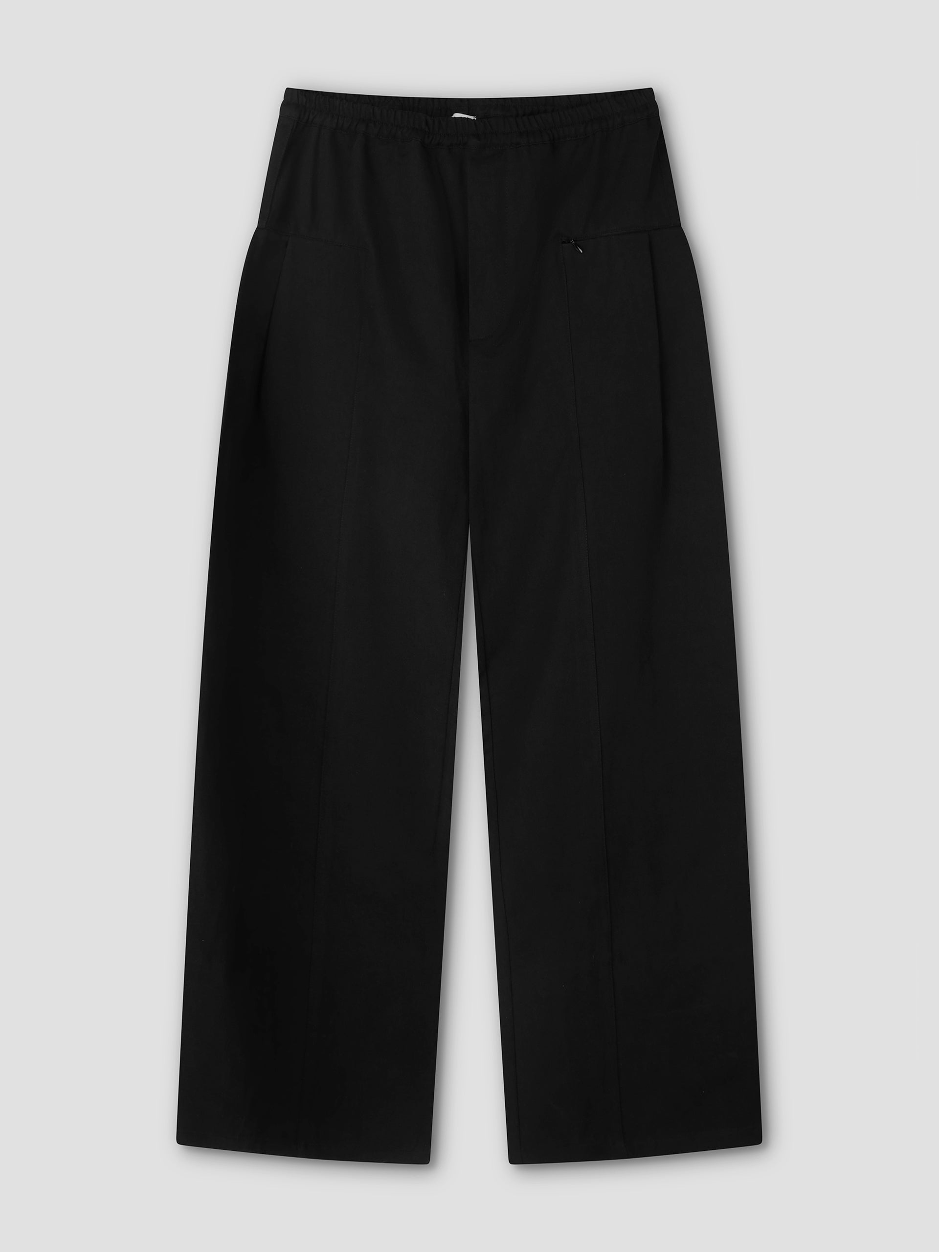 The Pleat Pant - Black is a pair of relaxed, straight-leg pants with an elastic waistband and subtle front seams, shown flat on a light gray background.