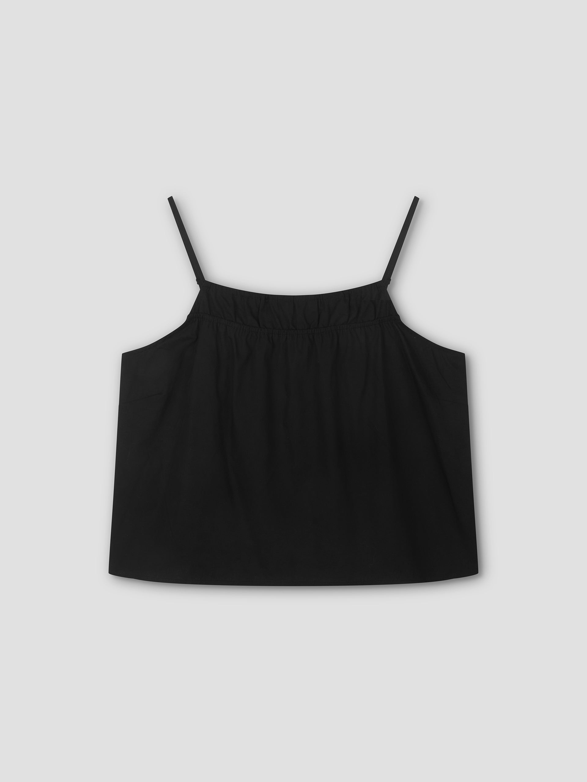 The Double Layer Top - Black by Deiji Studios features thin spaghetti straps, a gathered elastic neckline, and a relaxed, flowy fit. Shown against a light gray background.