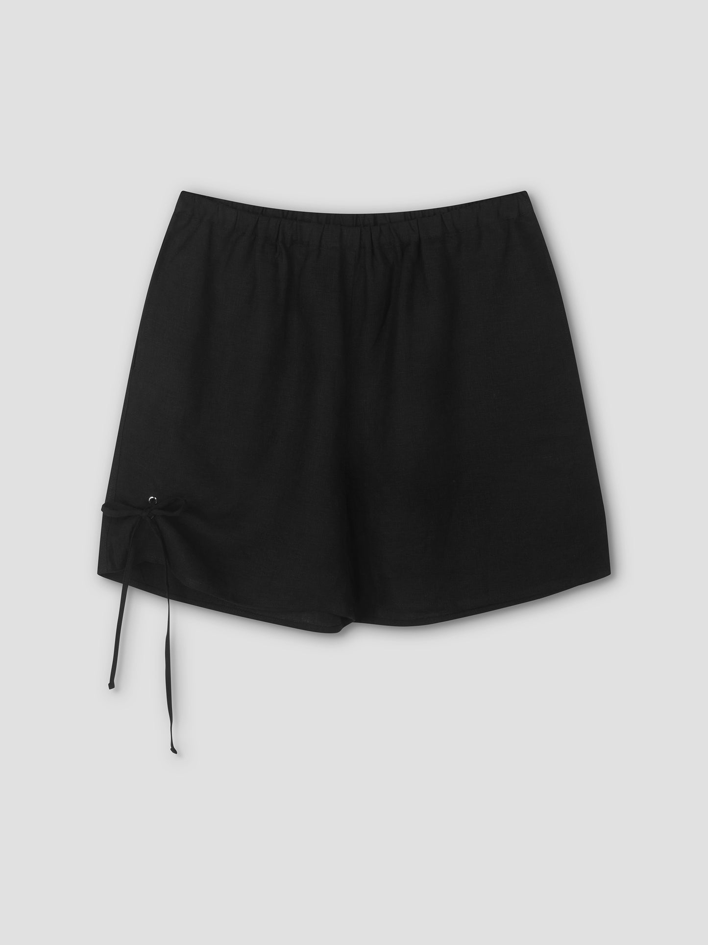 The Eyelet Short - Black features an elastic waistband and a left-side drawstring, shown against a plain light gray background.