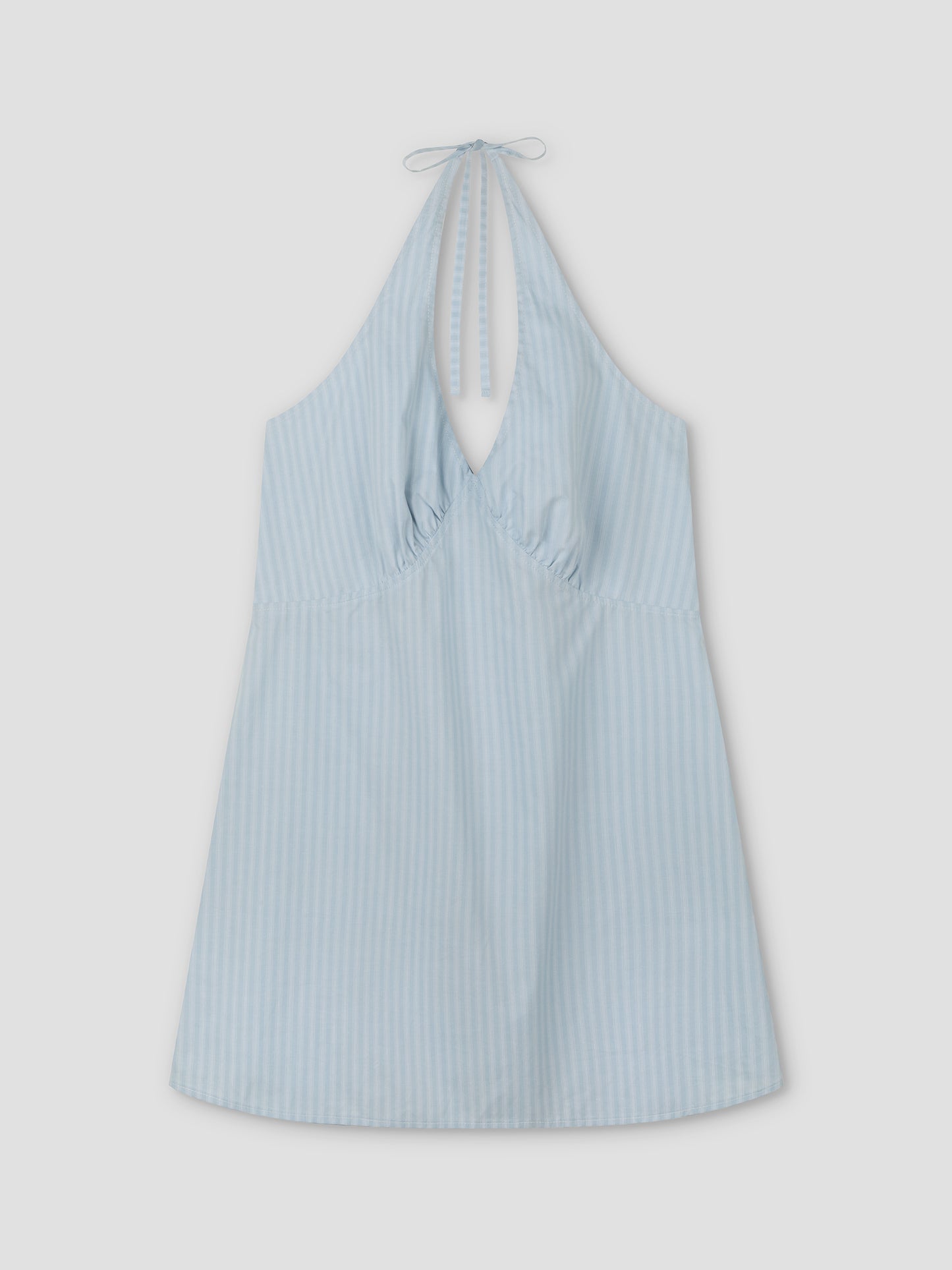 Cinched Halter Dress - Lake Blue Stripe from Deiji Studios, featuring light blue fabric with subtle vertical white stripes, a sleeveless design, gathered chest, and halter neck tie, shown laid flat on a white background.