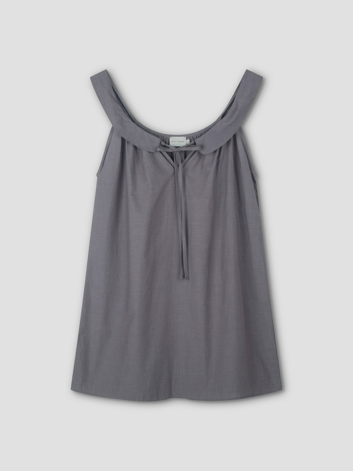 The Rounded Neck Dress - Currant features a sleeveless design with a wide, scooped neckline and front tie detail, shown against a plain light background.