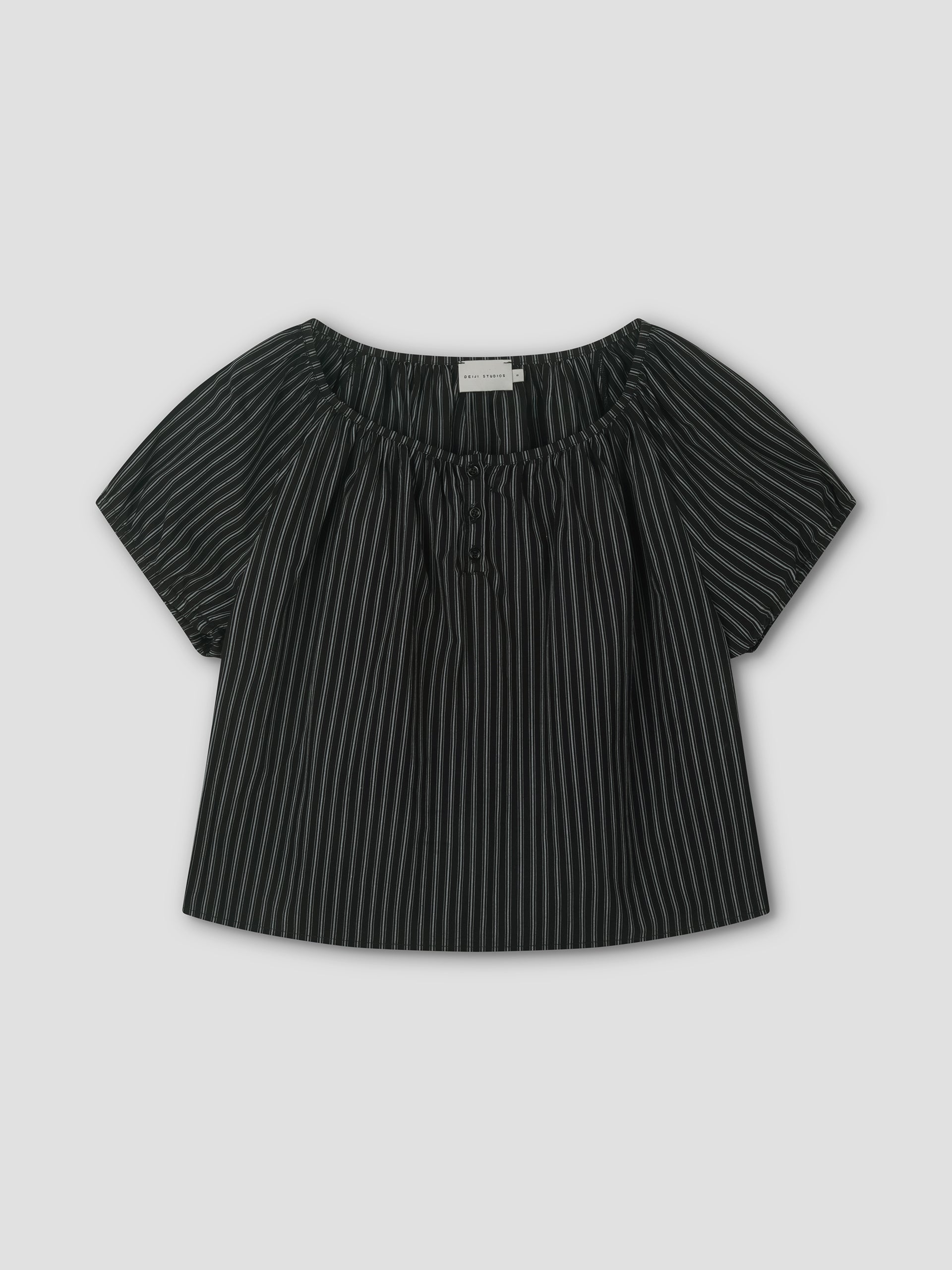 The Poplin T Shirt - Mono Stripe is a black short-sleeve blouse with white stripes, a loose fit, elastic gathered neckline, and center tie, styled like Deiji Studios. It’s displayed flat on a light gray background.