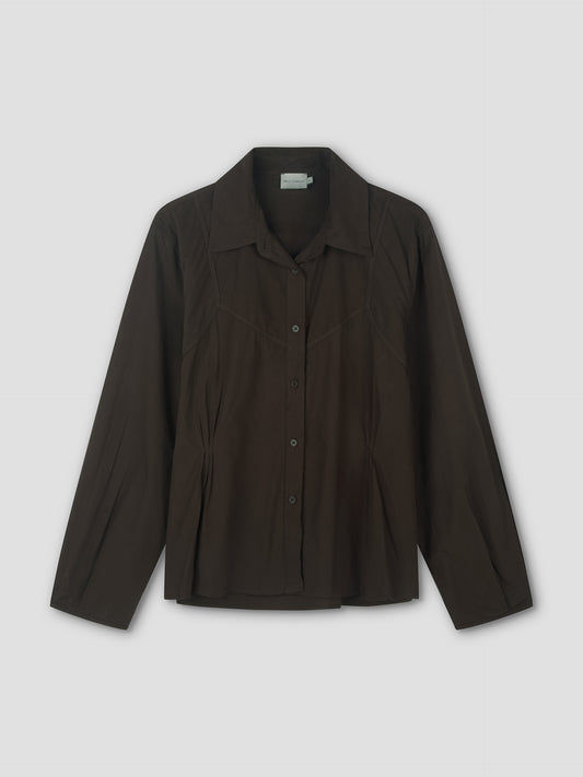 The Cami Overshirt in Sepia is a lightweight, long-sleeved button-up with a pointed collar and subtle pleat details, shown against a plain light background.