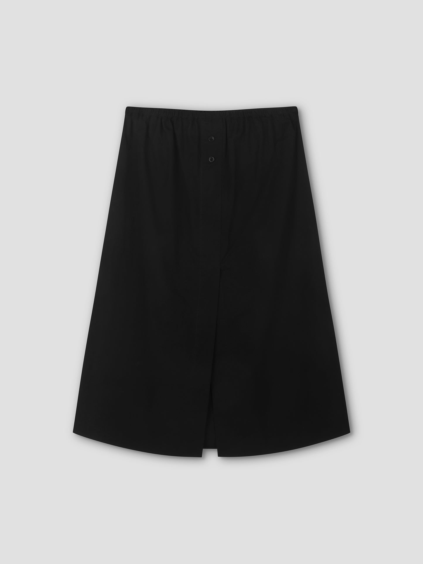 The Overlap Skirt - Black is a mid-length black skirt featuring a front slit and elastic waistband, shown against a plain light gray background.