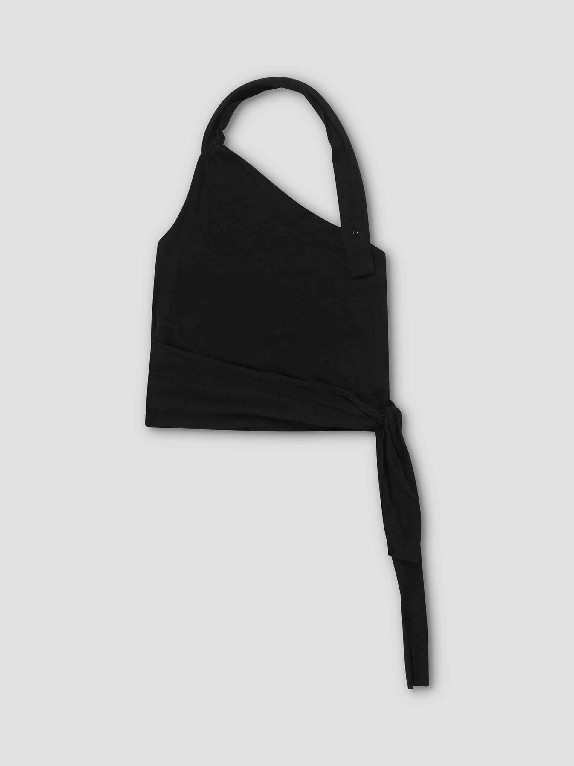 The Drape Halter - Black is an asymmetrical one-shoulder crop top with a thick strap and long waist tie, subtle gathered neckline, shown flat on a light gray background.