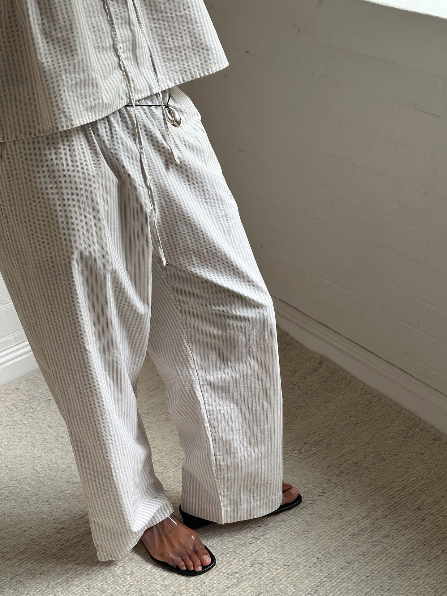 Female model wearing Ease Trouser - Story Stripe by Deiji Studios against plain background