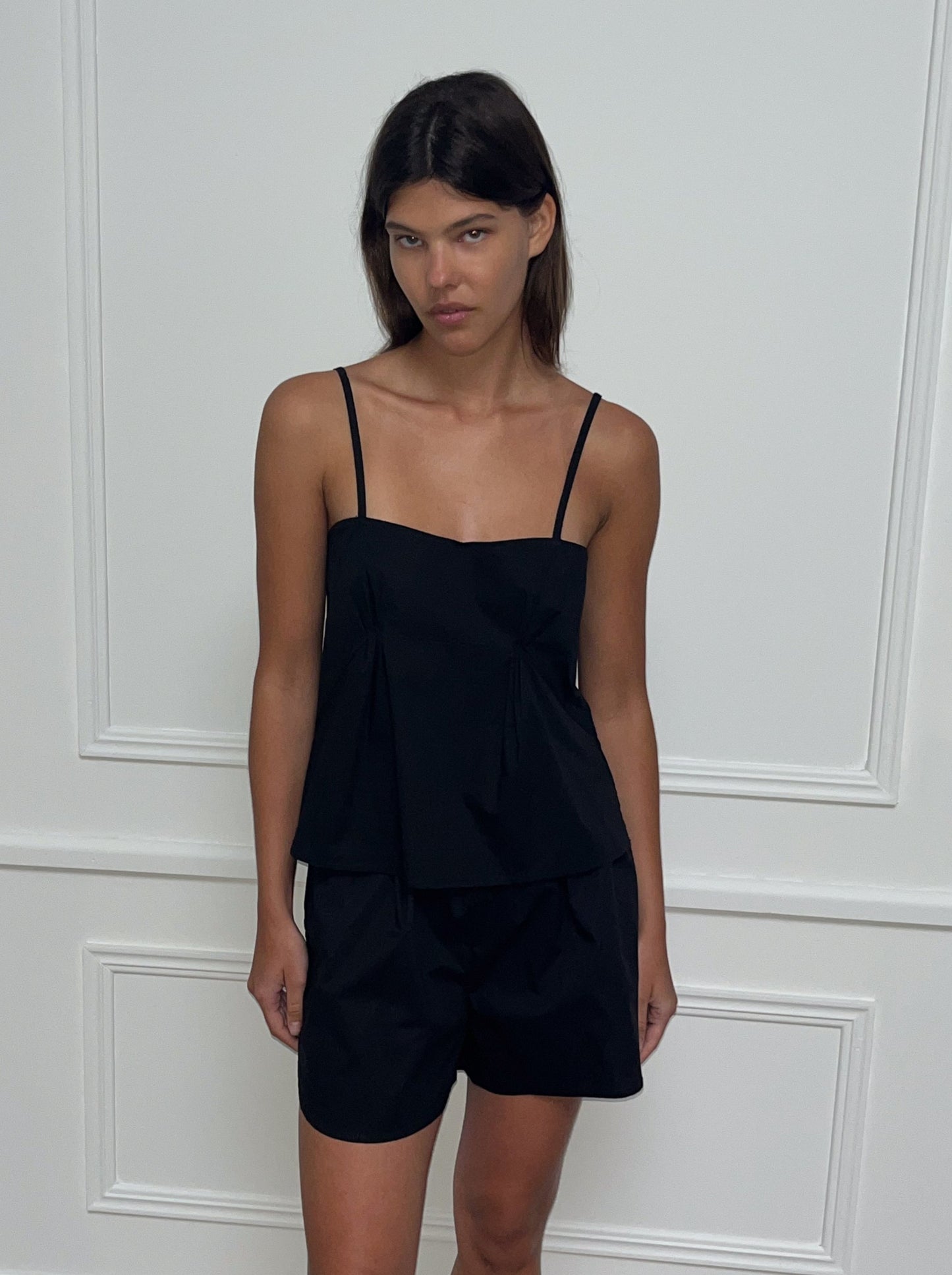 Female model wearing Pleat Top - Black by Deiji Studios against plain background
