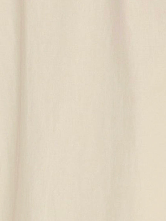 A close-up of the Light Dress - Butter White, made from light beige organic cotton with soft, vertical folds and a smooth texture.