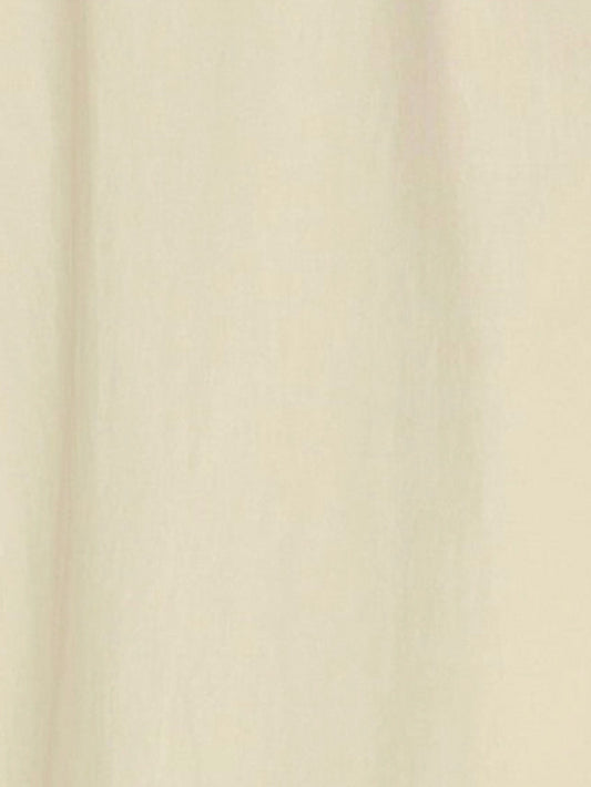 A close-up view of a soft, plain butter yellow fabric with subtle vertical folds, reminiscent of the Double Seam Dress by Deiji Studios made from organic cotton.