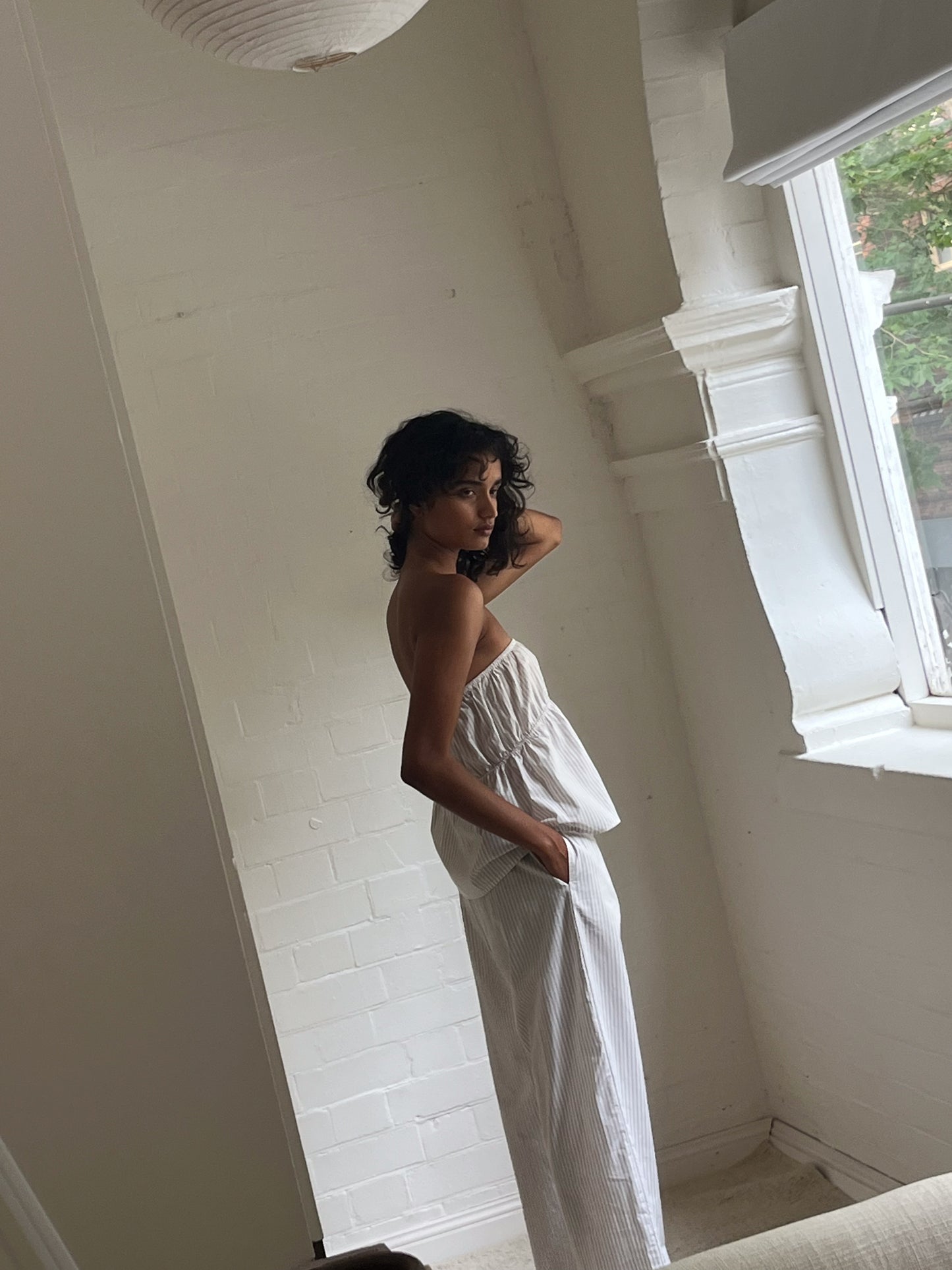 Female model wearing Ease Trouser - Story Stripe by Deiji Studios against plain background
