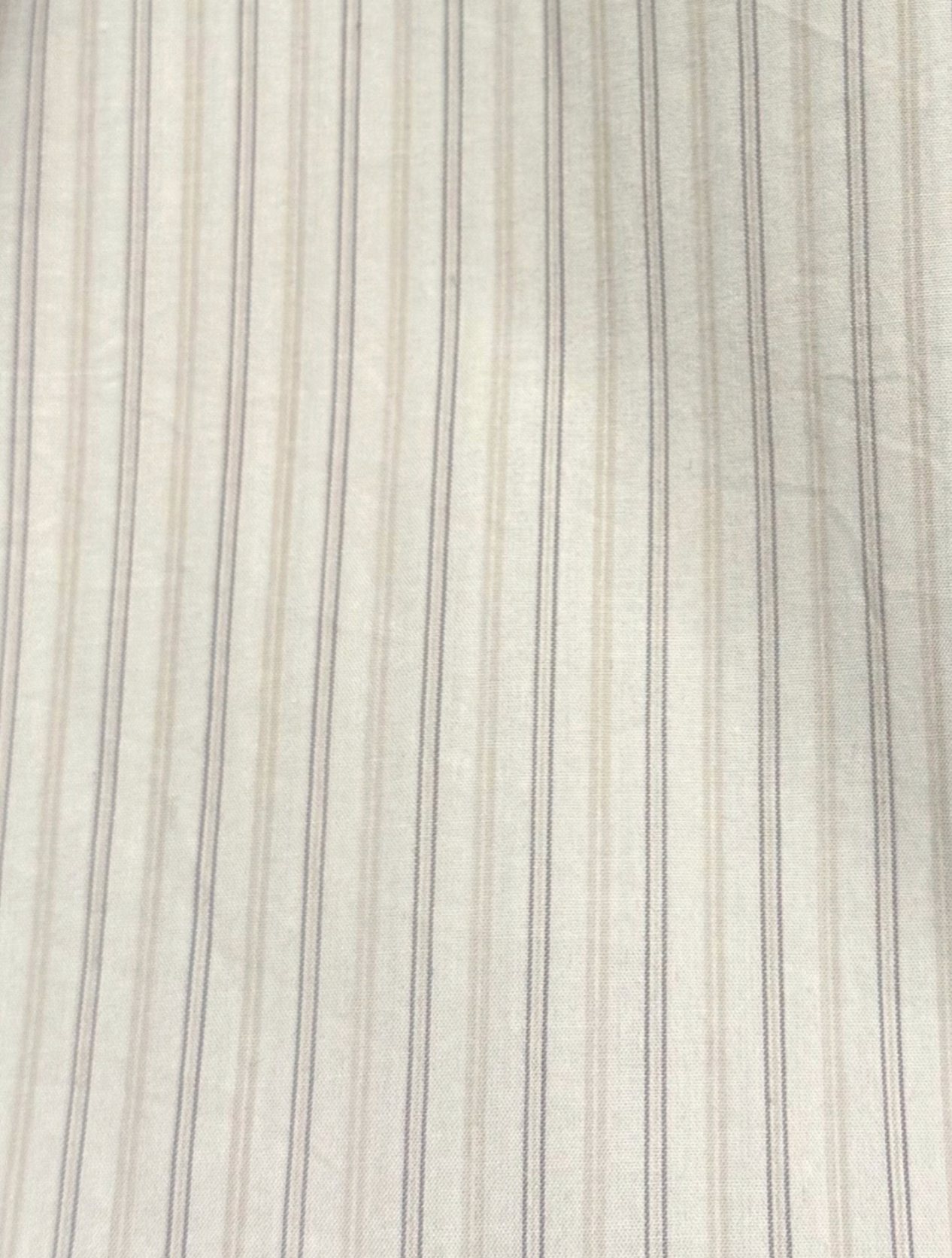 Close-up of the Napkin Belt - Pacific Stripe, crafted from smooth organic cotton featuring light-colored fabric with thin, evenly spaced darker vertical pinstripes and subtle wrinkles—true to Deiji Studios’ style.