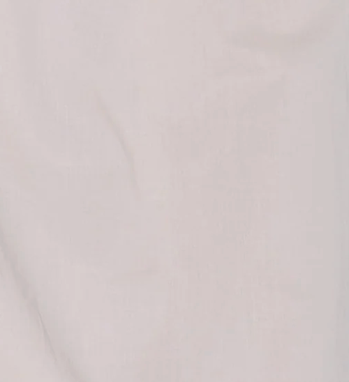 A close-up of light pink or off-white fabric with a soft, smooth texture and subtle creases, echoing the airy elegance of the Daytime Skirt - Floss by Deiji Studios—perfect for an effortless daytime look.