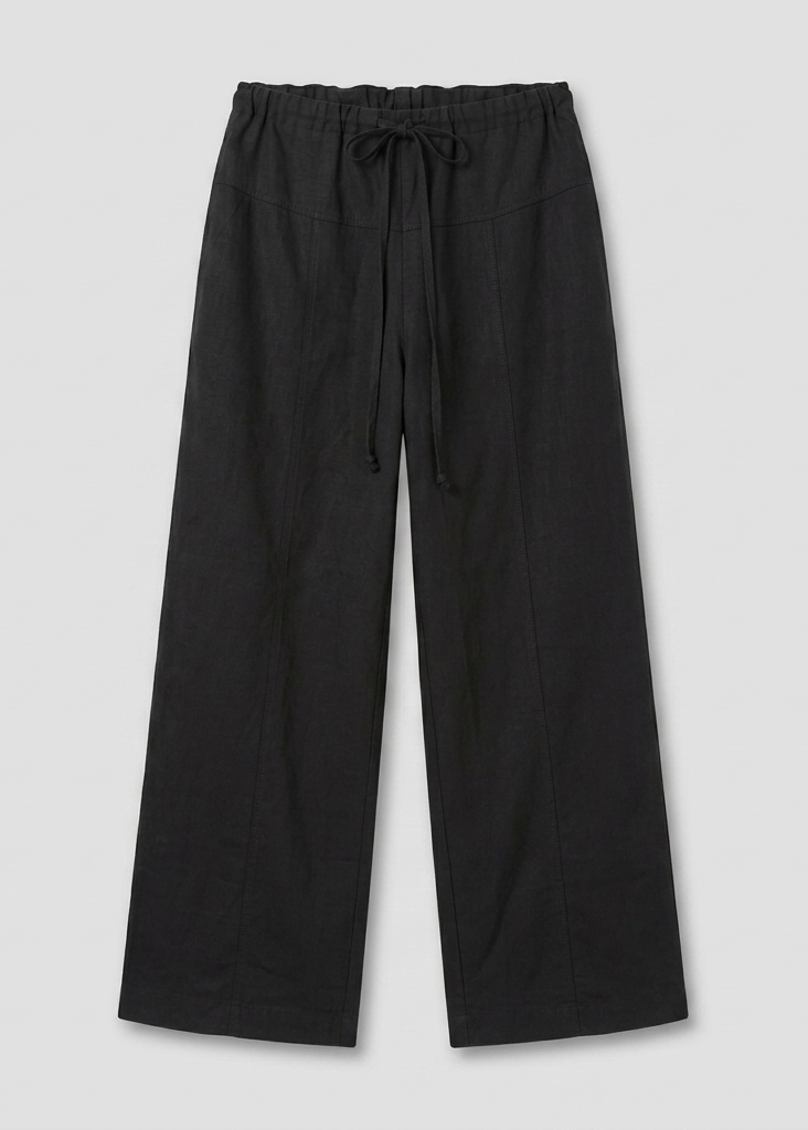The Seam Pant - Black features a comfortable fit, wide-leg design, elastic waist with drawstring, and is shown flat on a light gray background.