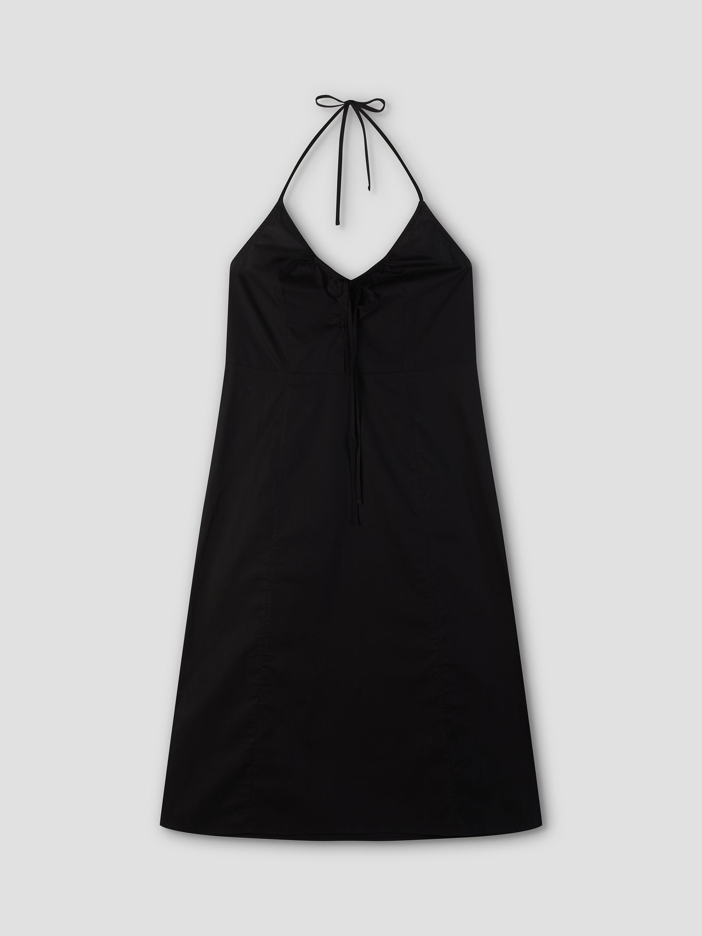 The Seamed Halter Dress - Black by Deiji Studios is a black midi dress with a V-shaped neckline, neck tie, and simple A-line silhouette. Shown flat on a light gray background.